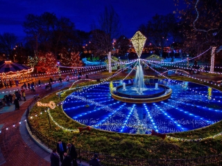 A Fountain With Lights In A Park With Franklin Square In The Background