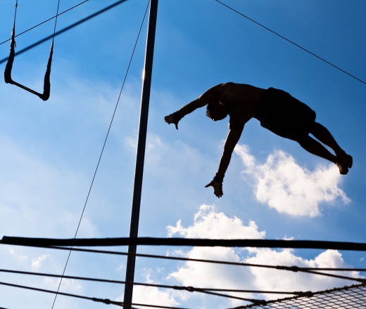 a person shown in the sky flying on the trapeze