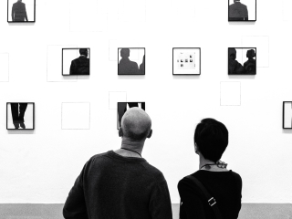 A Person And A Child Looking At A Wall With Pictures On It