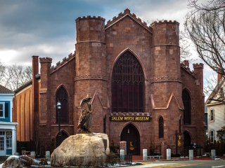 A Large Brick Building With A Statue In Front Of It